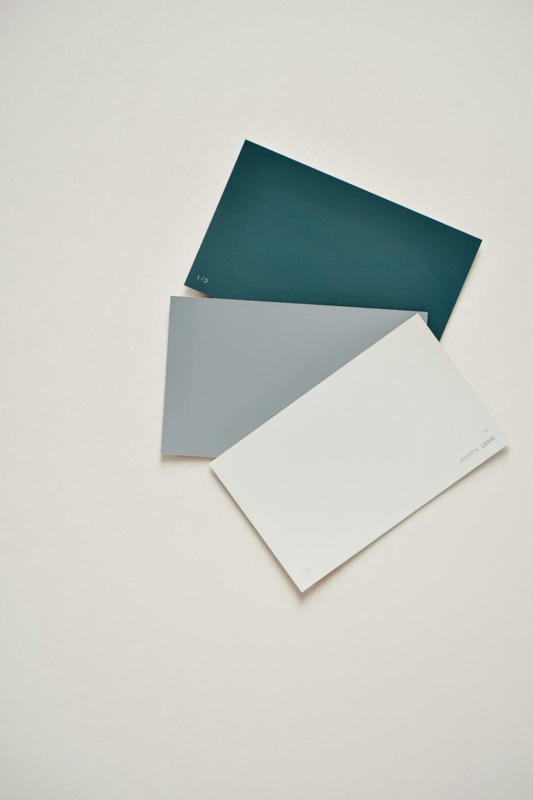 Three color swatches arranged on a neutral background in a minimalist style, featuring blue, gray, and white tones.