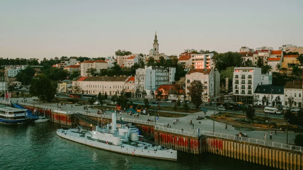 Belgrade waterfront promenade (Beton Hala) and historic buildings along the river bank.